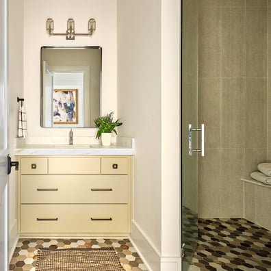Bathroom vanity with warm-toned cabinetry and hex tile flooring in a custom home in Charlotte, NC by Simonini Homes