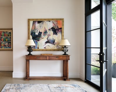 Entryway featuring wooden table, matching lamps, and modern artwork in a custom home in Charlotte, NC by Simonini Homes