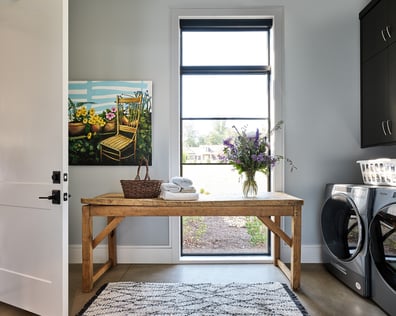 Charming laundry room with rustic table and floral decor in a custom home in Charlotte, NC by Simonini Homes