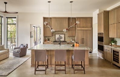 Warm-toned kitchen design with large island and custom cabinetry in a custom home in Charlotte, NC by Simonini Homes