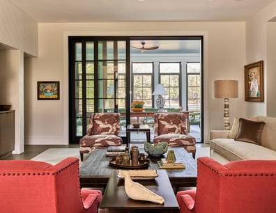 Stylish living room featuring patterned armchairs and large sliding glass doors in a custom home in Charlotte, NC by Simonini Homes