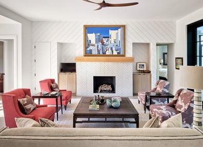 Fireplace-centered living room with bold artwork and herringbone wall pattern in a custom home in Charlotte, NC by Simonini Homes