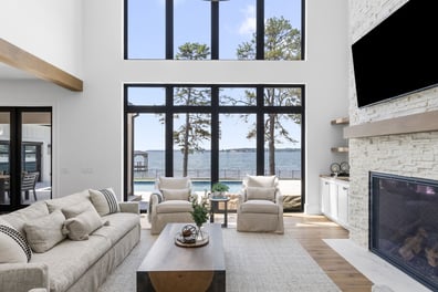 Lakefront living space with tall windows and cozy seating by Simonini Homes in Mooresville, North Carolina