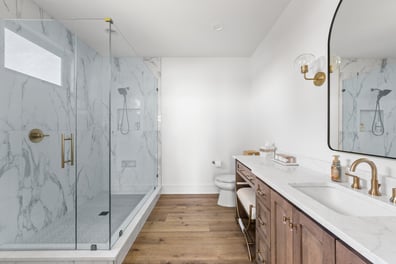Marble-accented bathroom with glass shower and double vanity in a Simonini Homes custom home, Mooresville, NC