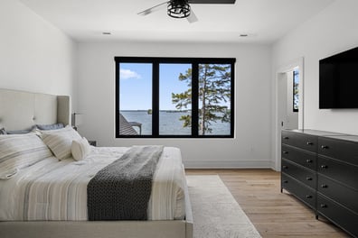 Tranquil bedroom design with expansive windows and water views by Simonini Homes in Mooresville, North Carolina