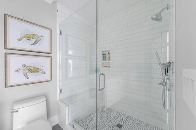 Stylish custom bathroom featuring glass shower and sea turtle artwork by Simonini Homes in Mooresville, NC