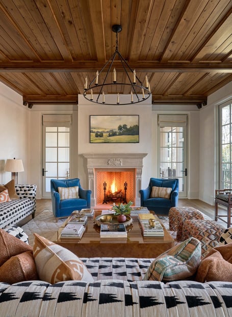 Central fireplace framed by blue armchairs in a custom home in Eastover, Charlotte by Simonini Homes