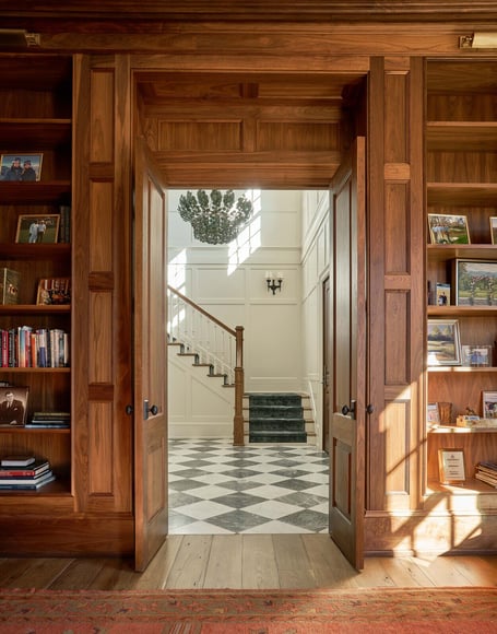 Framed view of marble foyer through library doorway in a custom home in Eastover, Charlotte by Simonini Homes