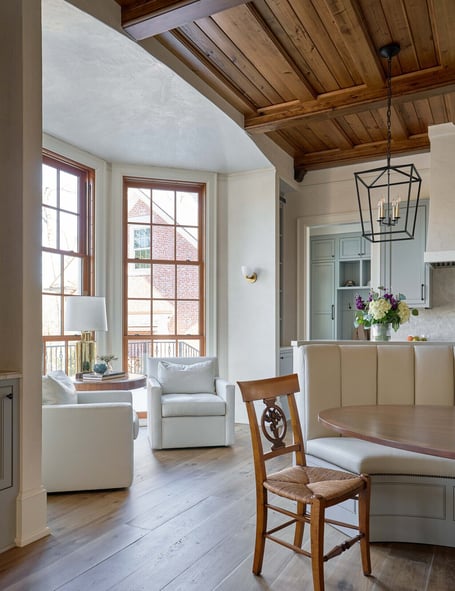Light-filled breakfast nook in a custom home in Eastover, Charlotte by Simonini Homes featuring white chairs and wood ceiling accents