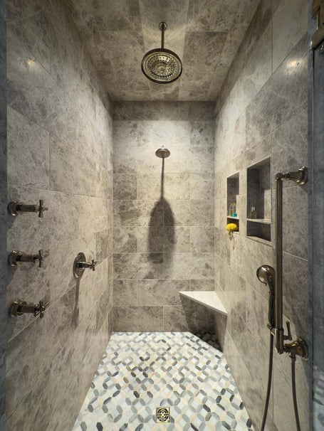 Luxurious tiled shower with built-in bench in a custom home in Eastover, Charlotte by Simonini Homes