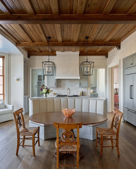 Round wood dining table beneath pendant lights in a custom home in Eastover, Charlotte by Simonini Homes