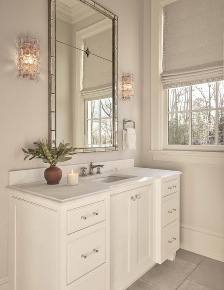 White vanity with large mirror and sconce lighting in a custom home in Eastover, Charlotte by Simonini Homes