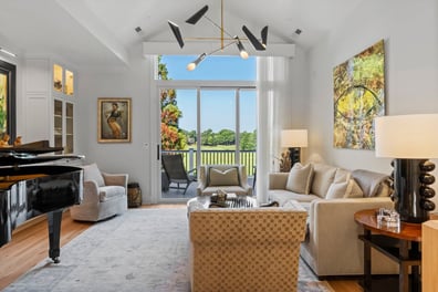 Bright living room with modern chandelier and golf course views from a renovation in Ballantyne, NC