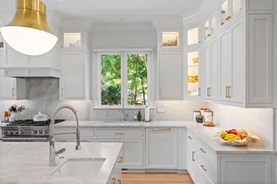 Bright white kitchen with marble countertops and double window from a renovation in Ballantyne, NC