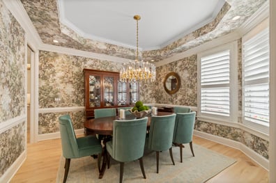 Formal dining room with crystal chandelier and patterned wallpaper from a renovation in Ballantyne, NC