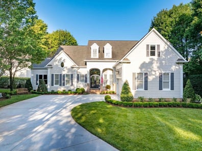 Front exterior of custom white home with manicured lawn from a renovation in Ballantyne, NC
