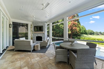 Screened-in patio with stone fireplace and pool view from a renovation in Ballantyne, NC