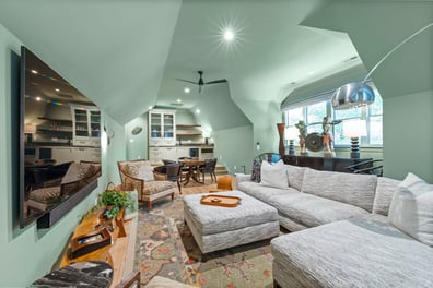 Spacious media and lounge area with sloped ceilings from a renovation in Ballantyne, NC