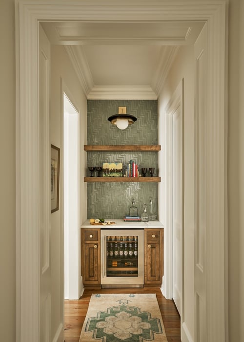 Custom hallway wet bar with wood cabinetry and green backsplash in Charlotte home by Simonini Homes