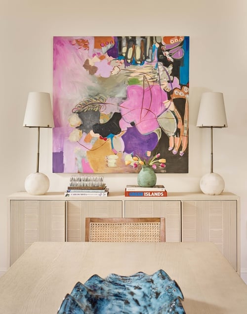 Simonini Homes brings bold color to a Charlotte dining room with abstract artwork and layered decor