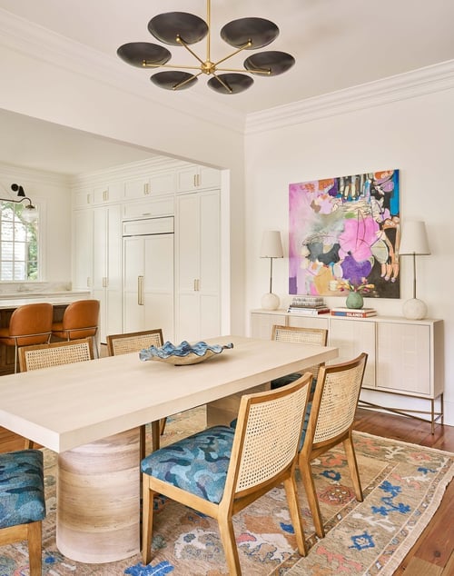 Simonini Homes dining area in Charlotte custom home with modern chandelier and vibrant artwork