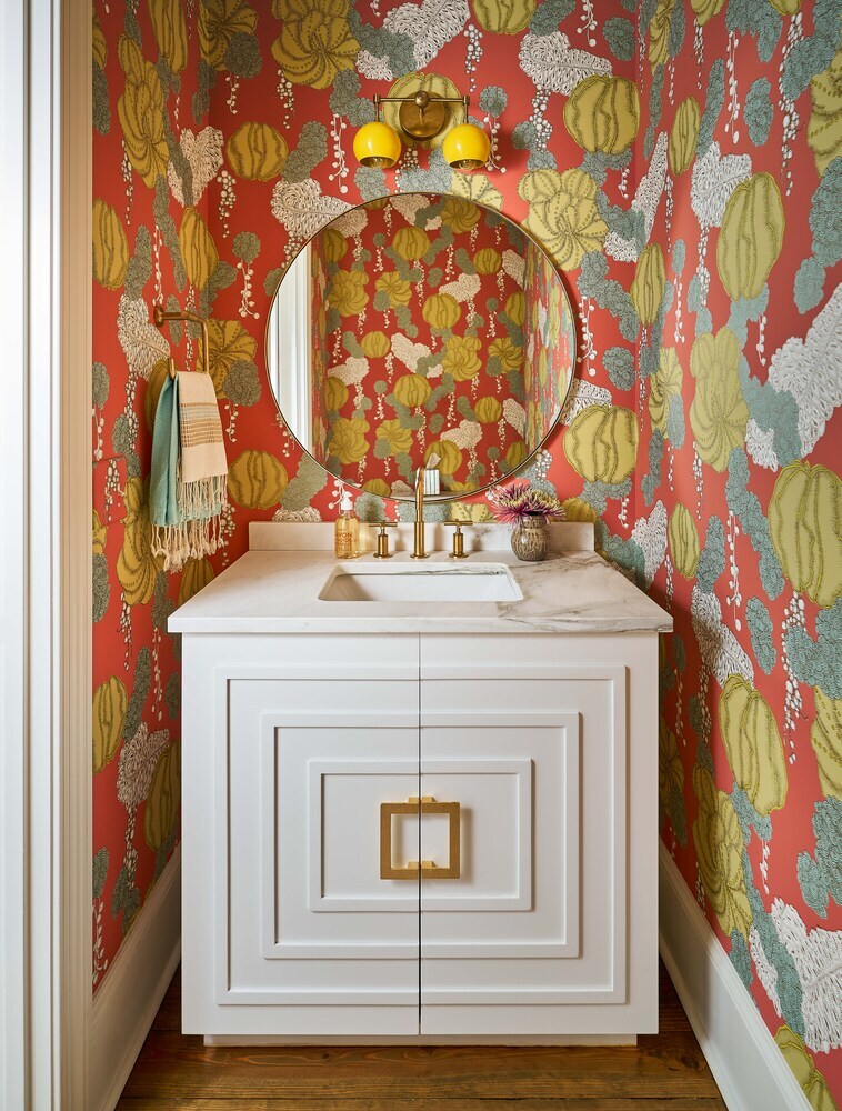 Vibrant powder room with red floral wallpaper and gold accents in Charlotte custom home by Simonini Homes