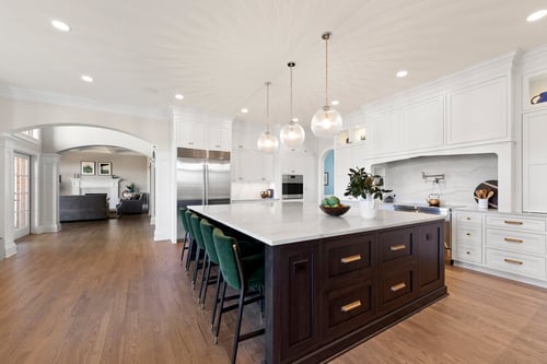 Luxury kitchen with marble island and open flow into living space in a custom home in Charlotte, NC