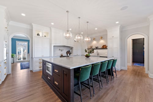 Open-concept kitchen design with hardwood floors and white cabinetry in a Charlotte, NC custom home