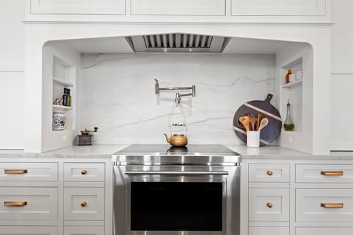Stainless range framed by marble backsplash in a custom home kitchen in Charlotte, NC