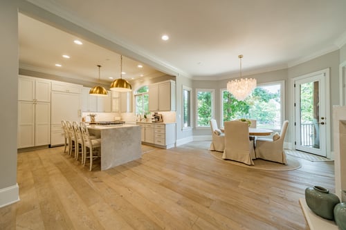 Bright open-concept kitchen and dining area with gold pendant lights in a custom home in Charlotte, NC