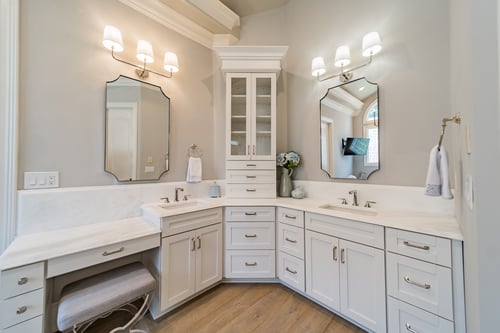 Double-sink vanity with custom cabinetry and mirrors of primary suite bathroom in a custom home in Charlotte, NC