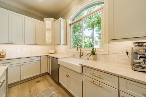 Large kitchen window with apron sink and gold hardware in a custom home in Charlotte, NC