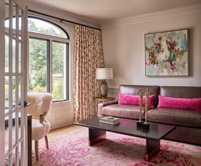 Bright living room with pink accents and large windows in a custom home by Simonini Homes in Foxcroft, NC