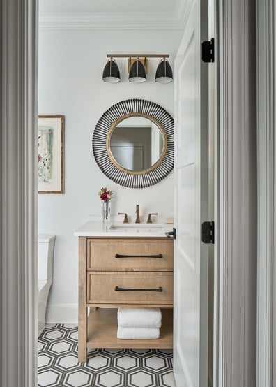 Custom powder room with wood vanity and decorative mirror by Simonini Homes in Mooresville, NC