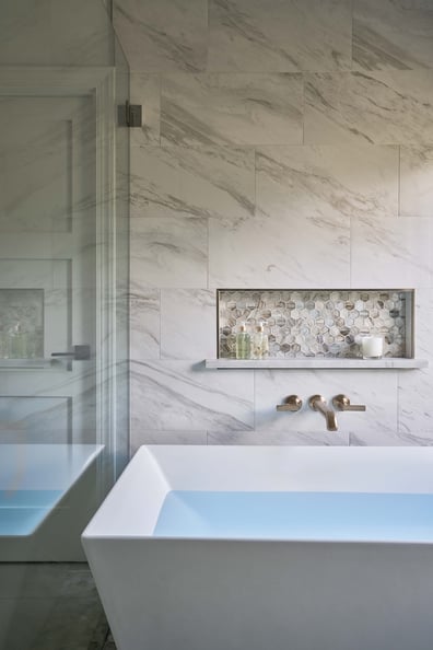 Freestanding soaking tub with tile backsplash in a Simonini Homes bathroom remodel in Mooresville, NC