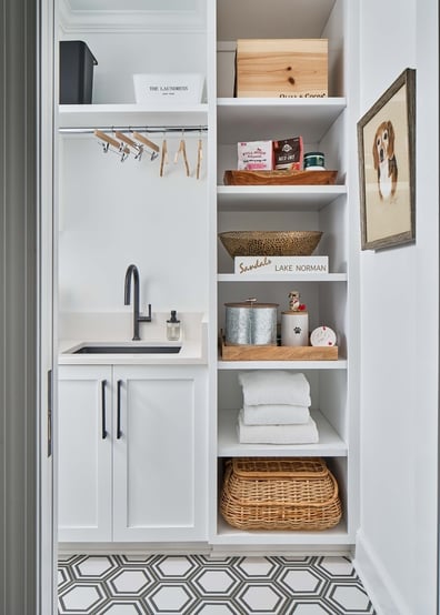 Functional laundry area with sink and shelving in a custom residence by Simonini Homes in Ballantyne, NC