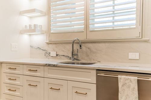 Close-up of sink and marble backsplash under window in a Charlotte, NC renovation