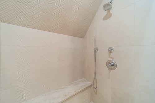 Detailed tile and built-in bench in walk-in shower from a Charlotte, NC renovation.