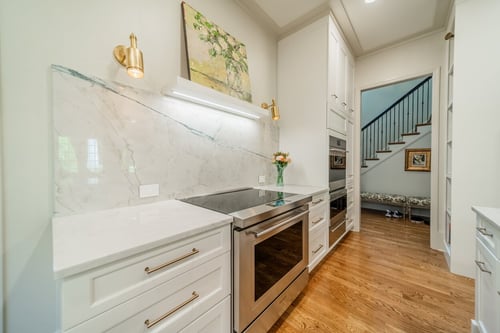 Detailed view of a marble backsplash and induction cooktop during a renovation in Charlotte, NC