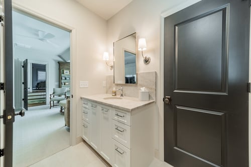 Guest bathroom with white vanity and neutral tile from a Charlotte, NC renovation