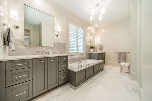 Spacious primary bathroom with gray vanities and soaking tub from a renovation in Charlotte, NC