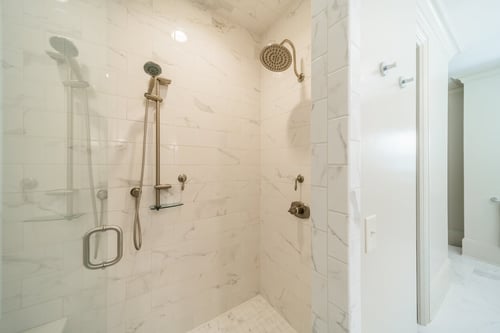 Walk-in shower with white subway tile and rainfall head from a renovation in Charlotte, NC