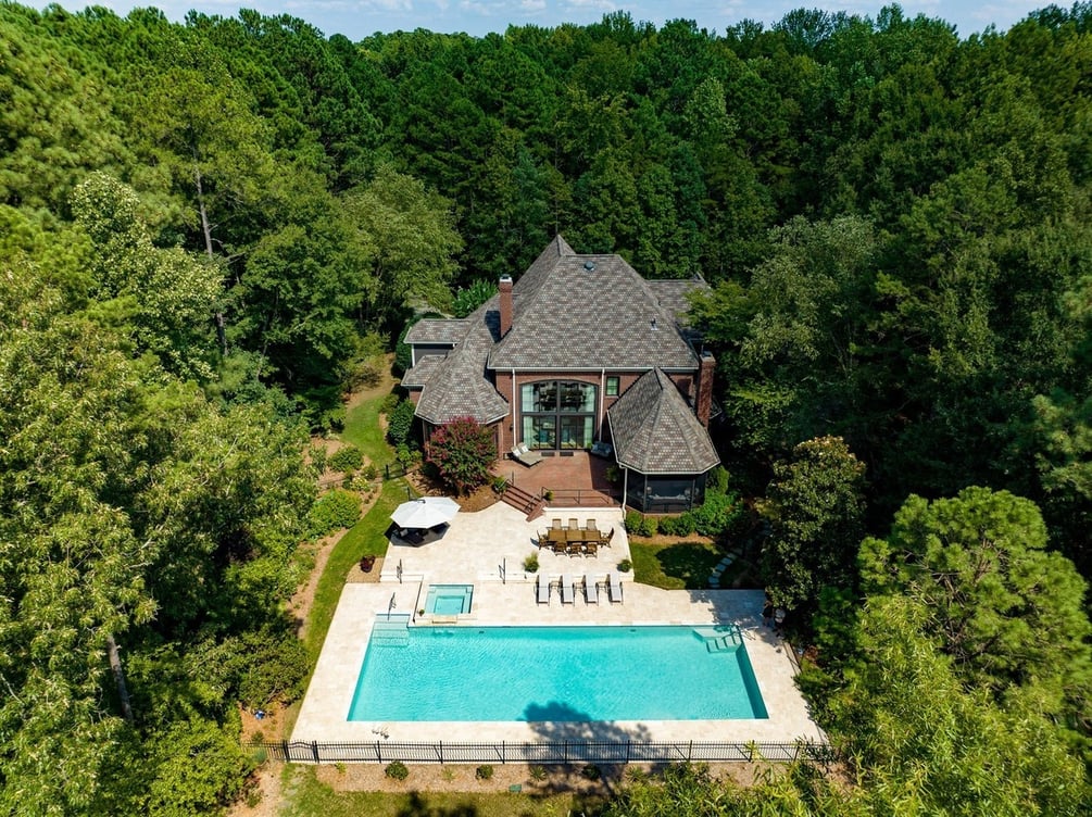 Aerial view of custom home in Ballantyne, NC built by Simonini Homes featuring a beautiful back patio and pool