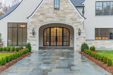 front entry of Simonini Homes custom home with arched doorway and black framed glass doors in Waxhaw NC-optimized