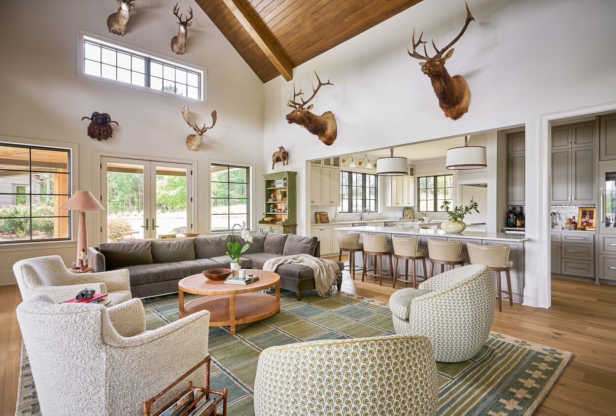 Open living and kitchen area with mounted elk heads at Custom Hunting Lodge in Fort Lawn, NC by Simonini Homes.-1