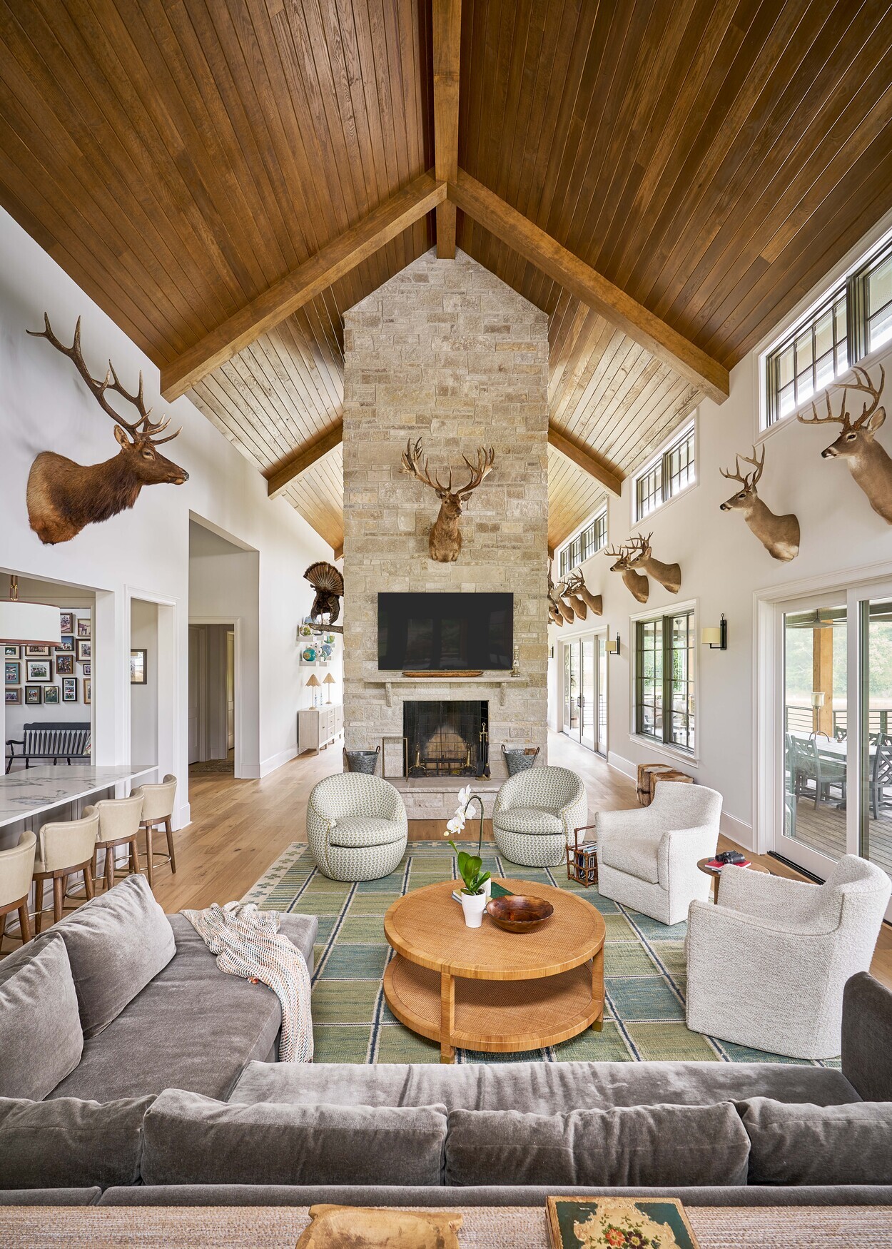Vaulted great room with stone fireplace and taxidermy in custom hunting lodge in Fort Lawn, NC by Simonini Homes